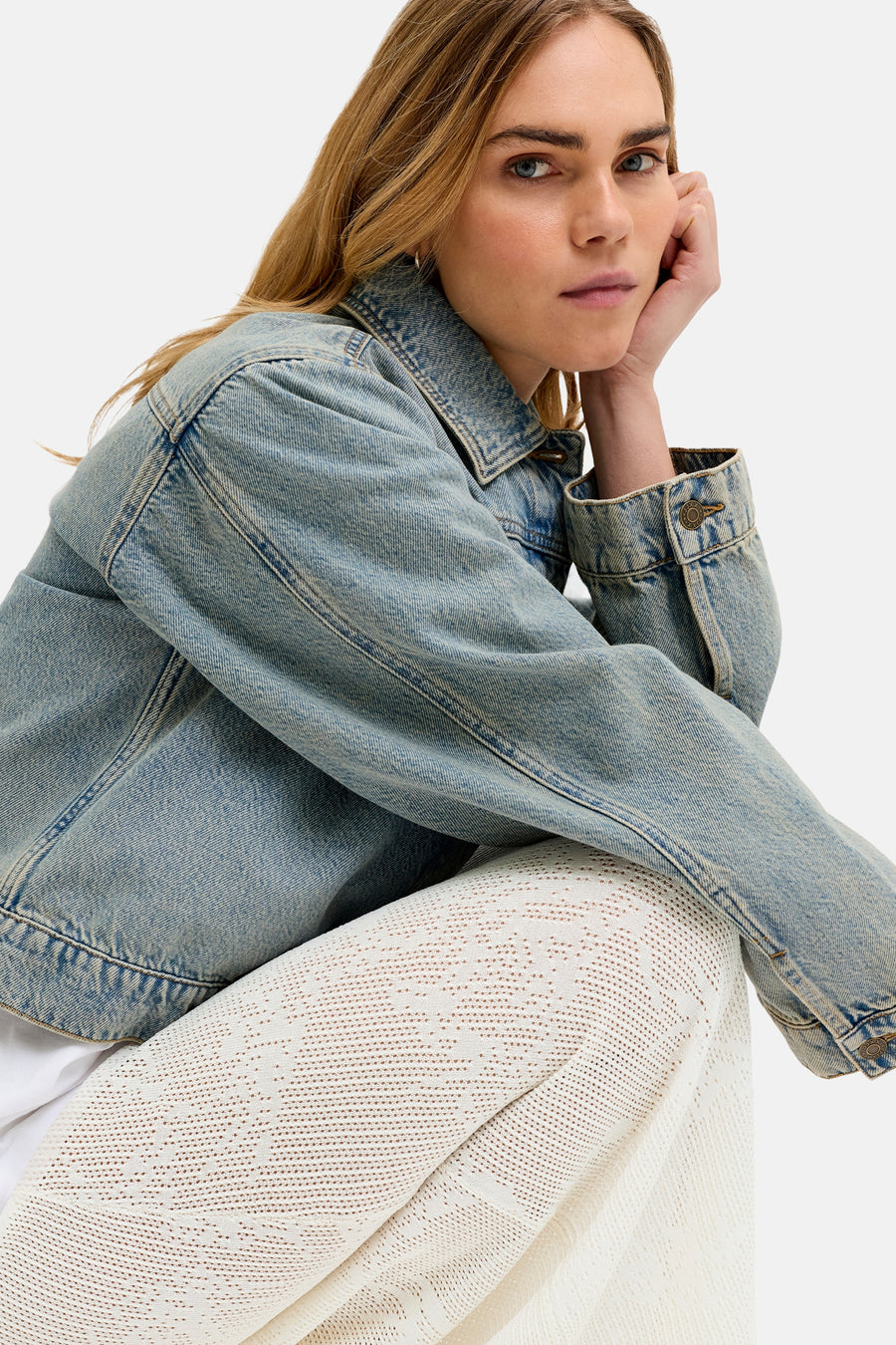 Jupe longue blanche de JJXX avec motif ajouré délicat, portée sous une veste en jean bleu clair.