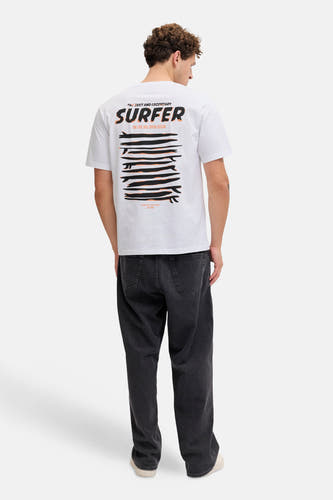T-shirt blanc JJREBEL, avec un imprimé surfeur au dos, combiné avec un jean foncé et des baskets claires.
