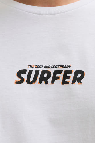 T-shirt blanc JJREBEL, avec une impression noire du texte "The best and legendary surfer".
