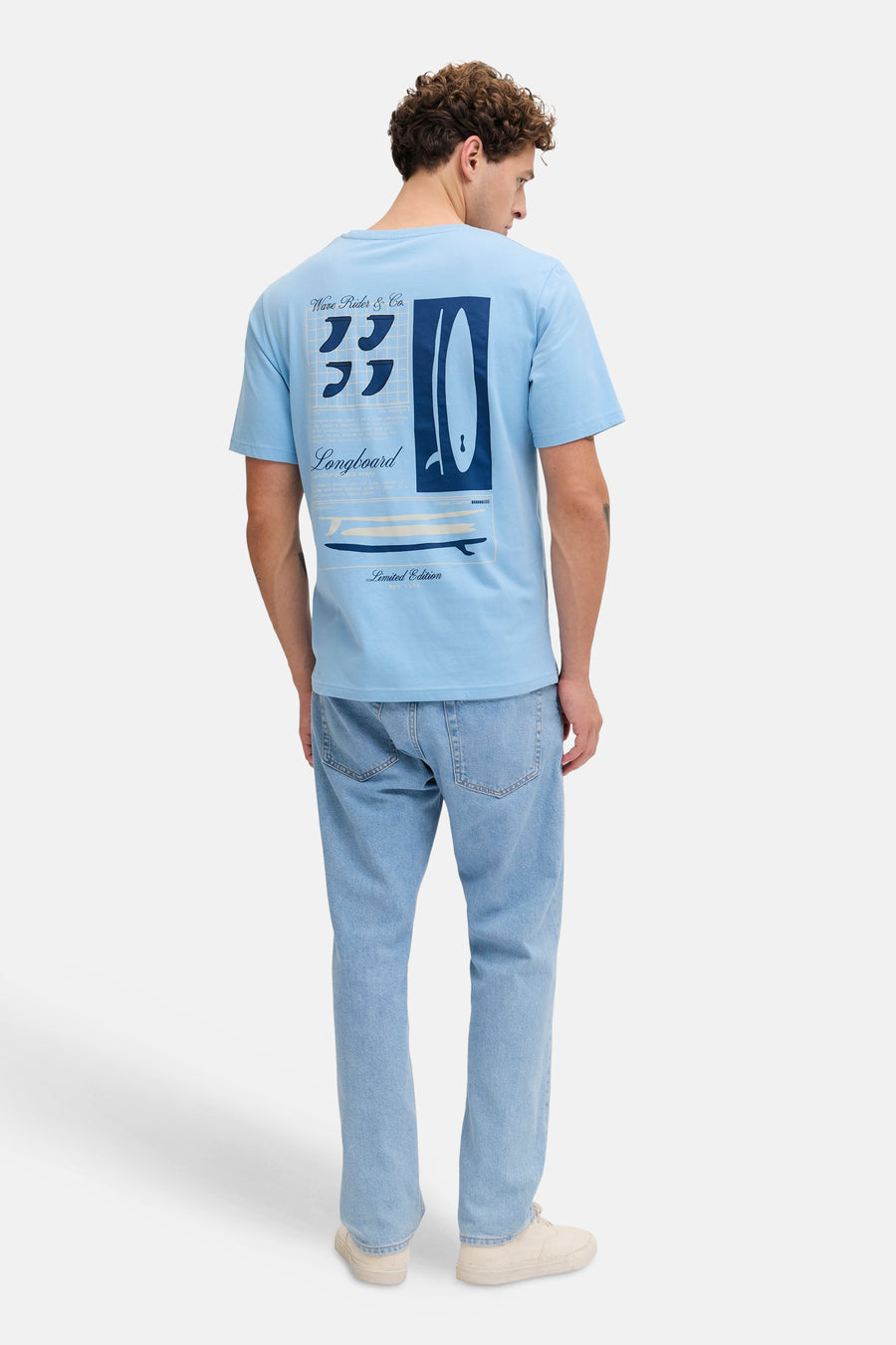 T-shirt bleu de JJREBEL, avec un imprimé surf au dos, à combiner avec un jean clair et des baskets beiges.