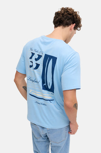 T-shirt bleu de JJREBEL, avec imprimé surf au dos, combiné avec un jean bleu clair.