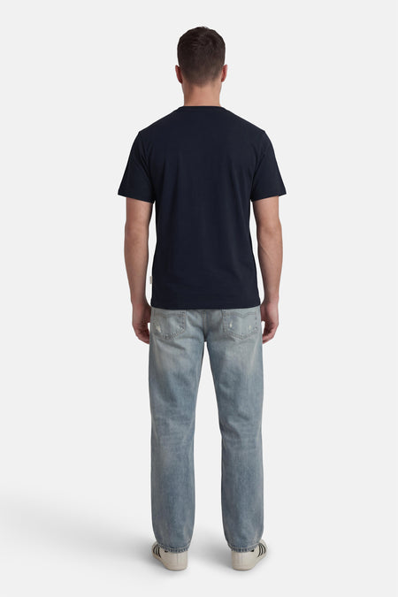 T-shirt bleu à manches courtes de ORIGINALS BY JACK & JONES, vu de dos avec jean et baskets.