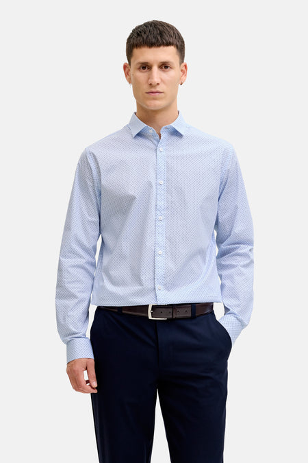 Chemise bleue à manches longues de PREMIUM by JACK & JONES, avec un motif à petits pois fins, combinée avec un pantalon foncé et des chaussures en cuir.