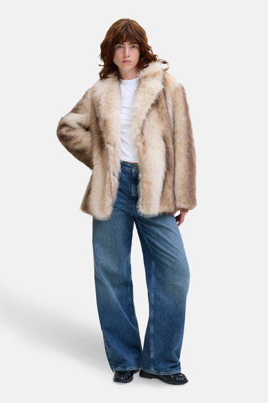 Manteau ecru court de JJXX, porté sur un t-shirt blanc et des jeans larges.