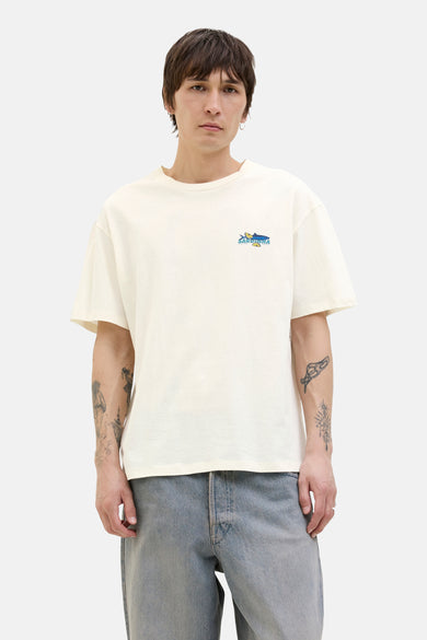 T-shirt blanc à manches courtes d'ORIGINALS BY JACK & JONES, avec une petite image sur la poitrine, porté avec un jean.