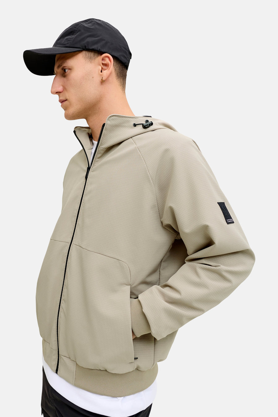 Manteau court beige de CORE BY JACK & JONES, avec capuche, motif à carreaux et détails noirs.