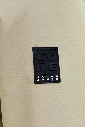 Manteau court beige de CORE BY JACK & JONES, avec une texture subtile et un écusson logo.