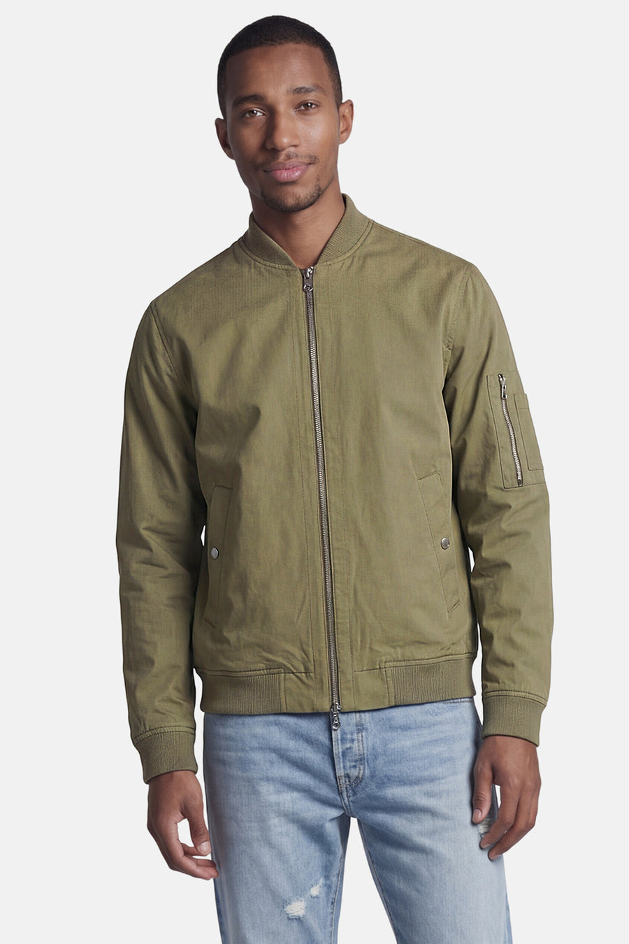 Veste courte verte de CORE BY JACK & JONES, style bomber avec fermeture éclair, poignets côtelés et poche sur la manche, portée par un homme.