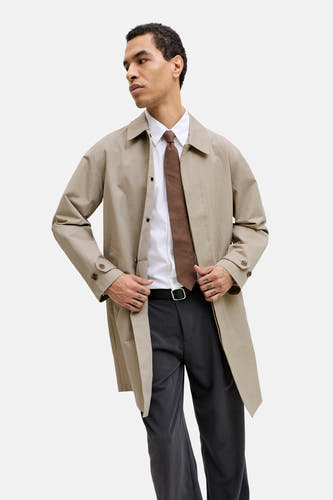Manteau court beige de PREMIUM by JACK & JONES, à manches longues et porté sur une chemise blanche, une cravate marron et un pantalon gris.