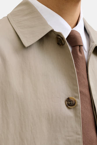 Manteau court beige de PREMIUM by JACK & JONES, avec fermeture à boutons et cravate marron.