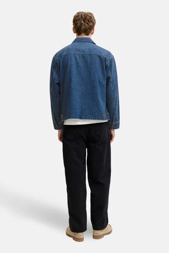 Veste en jean en denim bleu moyen de PREMIUM BLUE by JACK & JONES, vue de dos, avec un pantalon noir et des chaussures marron.