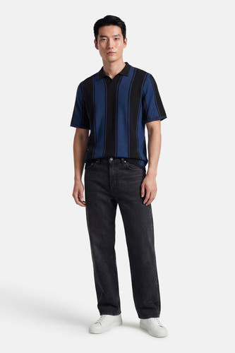 Polo multicolore à manches courtes de CORE BY JACK & JONES, avec des rayures noires et bleues, combinée avec un jean noir et des baskets blanches.