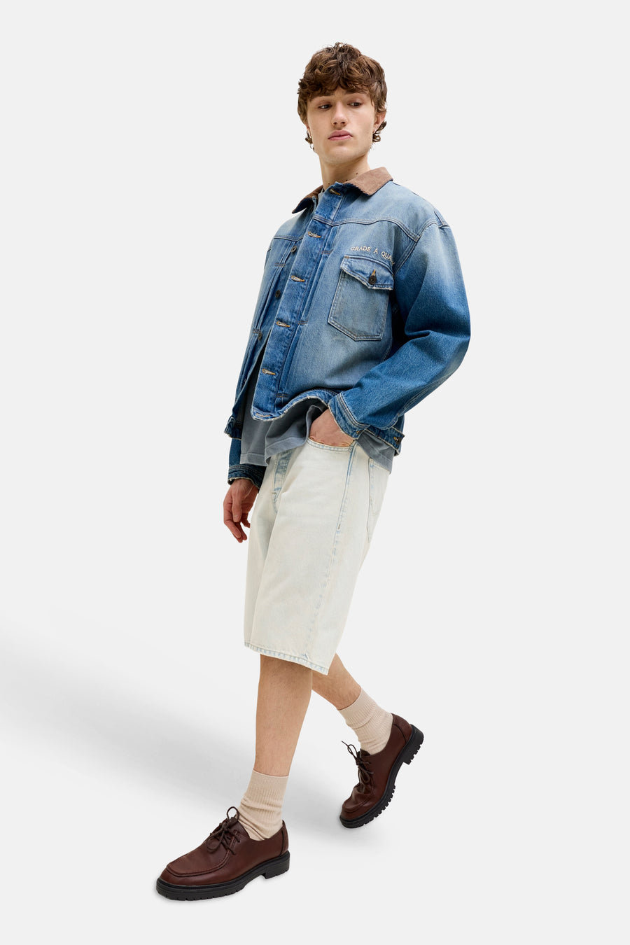 Short en jean bleu clair jusqu'aux genoux de JACK & JONES JEANS INTELLIGENCE, porté avec une veste en jean et des chaussures marron.