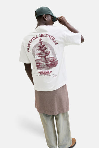 T-shirt blanc de ORIGINALS BY JACK & JONES, avec imprimé graphique au dos et combiné avec une jupe à carreaux et un jean ample.