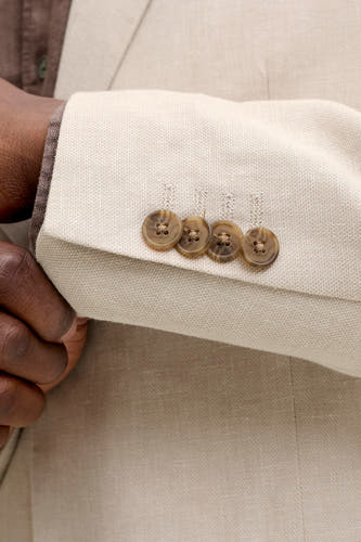 Blazer écru de PREMIUM by JACK & JONES avec un tissage sergé, détail de manche avec quatre boutons marron.