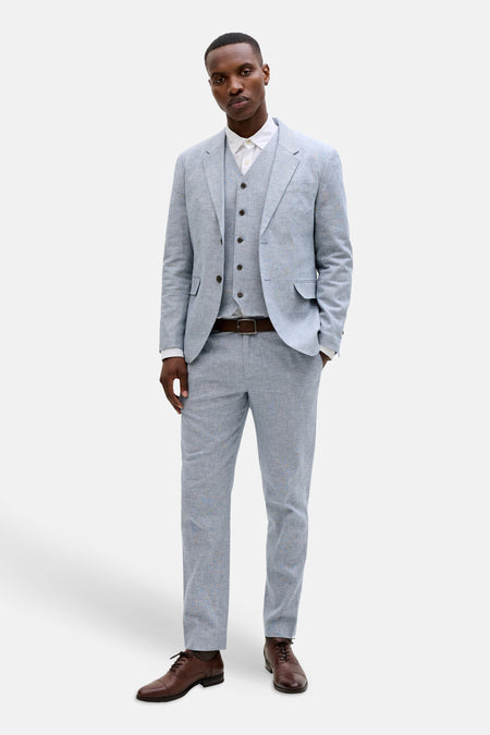 Lichtblauwe blazer van PREMIUM by JACK & JONES met linnen textuur, gedragen met vest en wit overhemd.