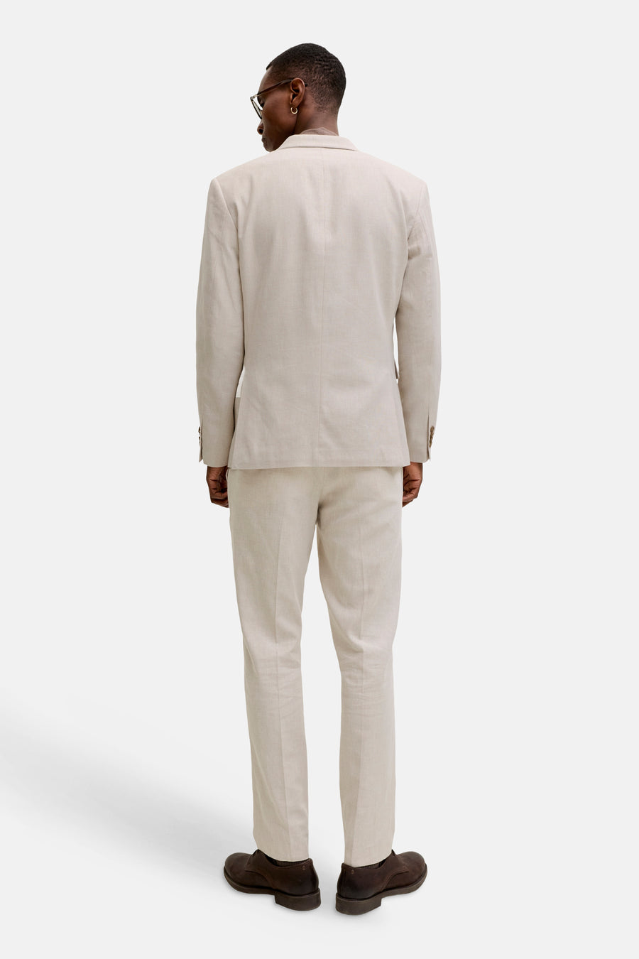 Pantalon de costume écru de PREMIUM by JACK & JONES, vu de dos, avec veste assortie et chaussures marron foncé.