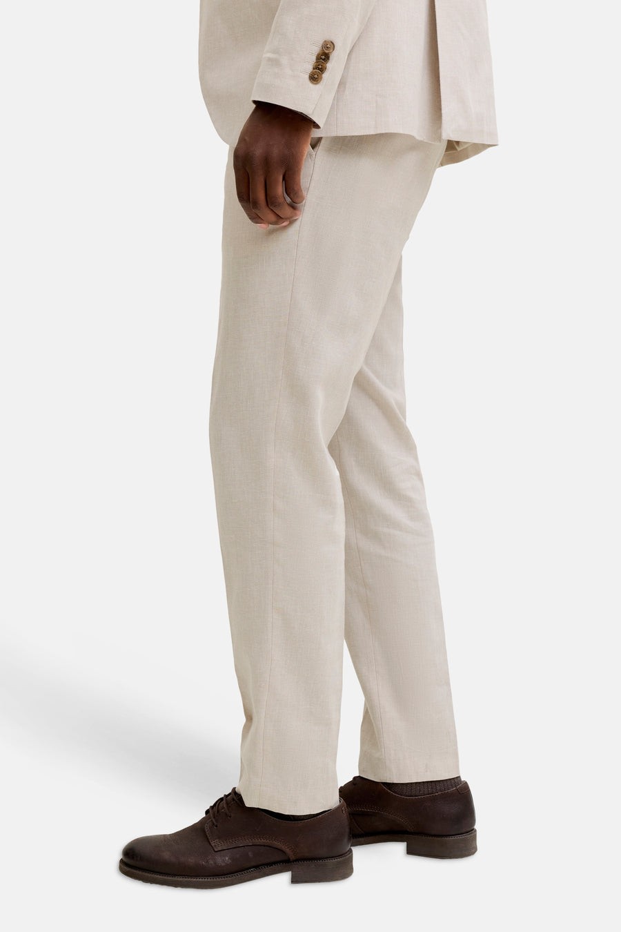 Pantalon de costume écru de PREMIUM by JACK & JONES, avec des chaussures en cuir marron et des chaussettes marron, en vue de côté.