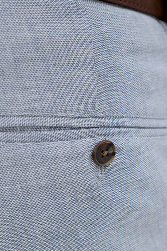 Pantalon de costume bleu de PREMIUM by JACK & JONES, gros plan de la poche à bouton et de la fine structure à chevrons.