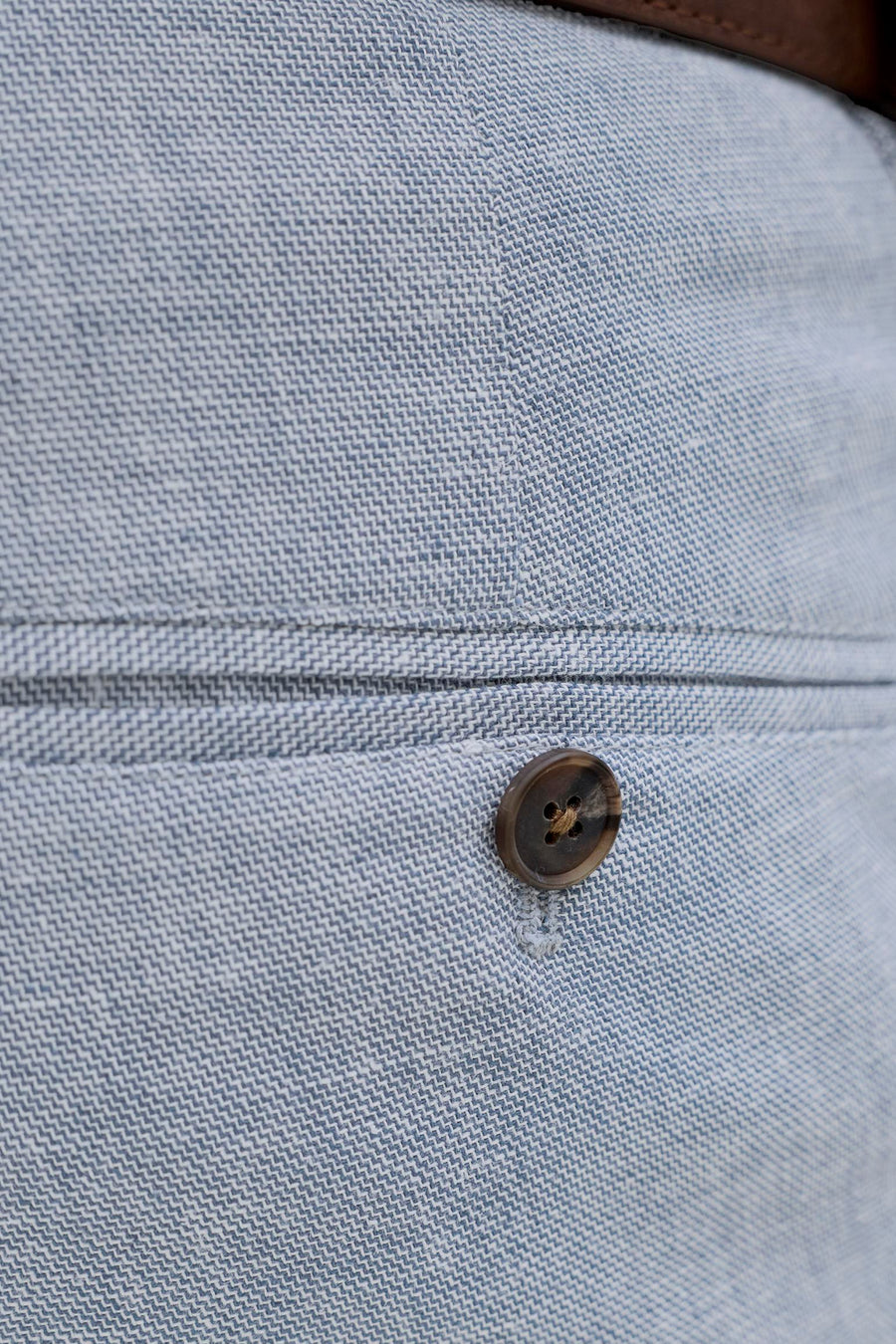 Pantalon de costume bleu de PREMIUM by JACK & JONES, gros plan de la poche à bouton et de la fine structure à chevrons.