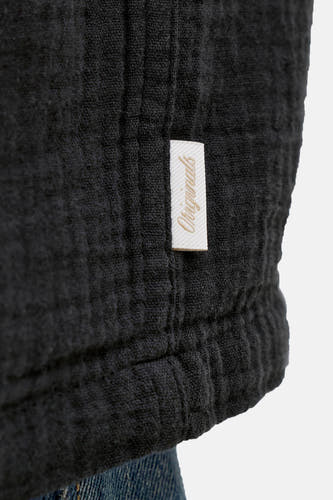 Chemise noire de ORIGINALS BY JACK & JONES, gros plan sur le tissu et une étiquette avec le nom de la marque.