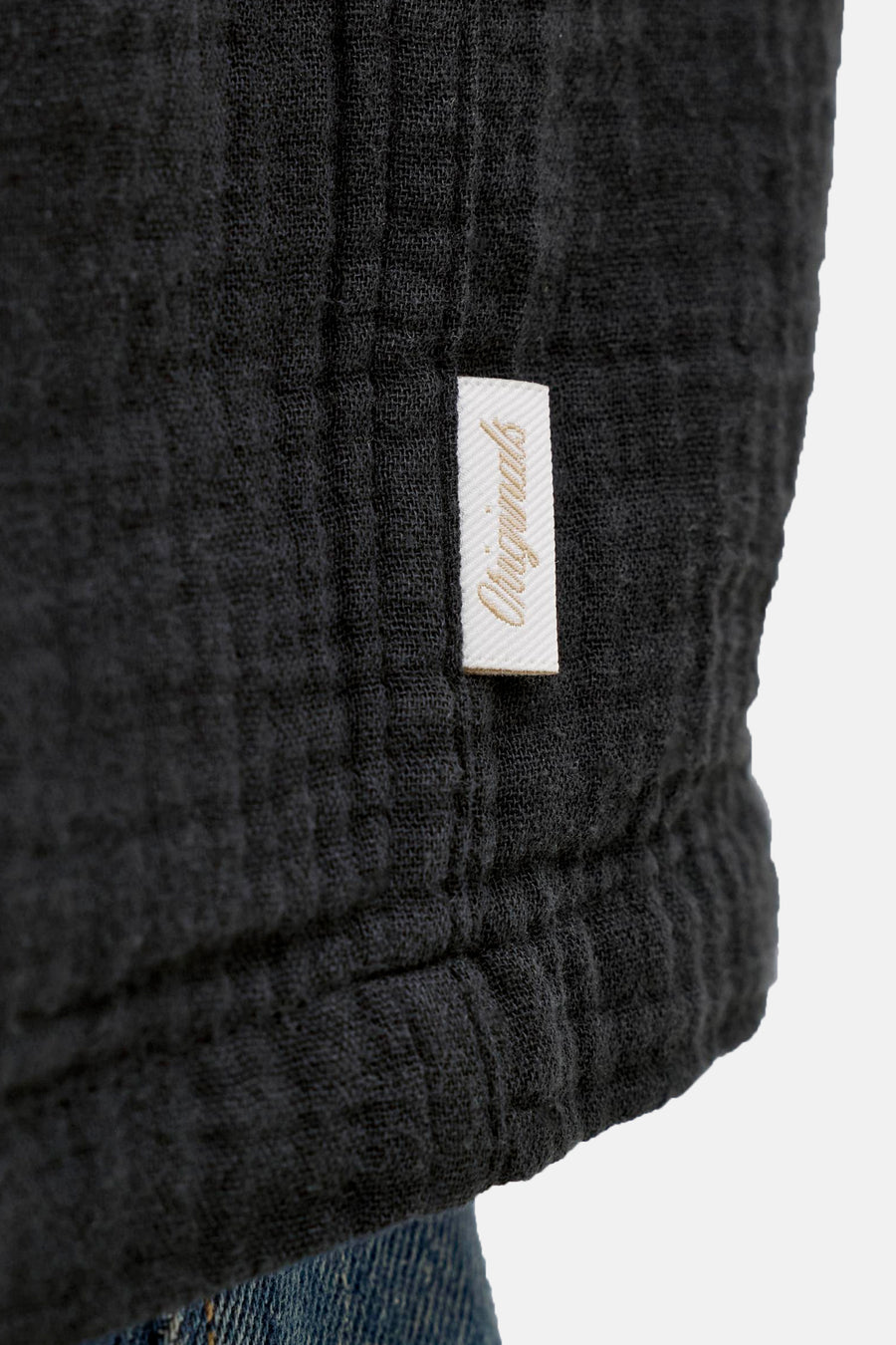 Chemise noire de ORIGINALS BY JACK & JONES, gros plan sur le tissu et une étiquette avec le nom de la marque.