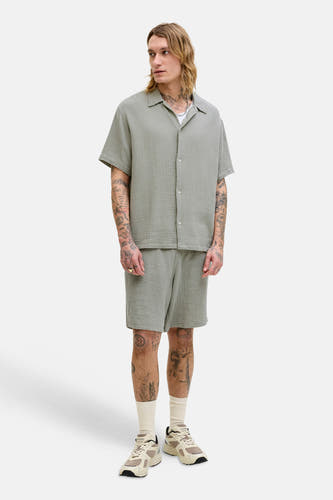 Chemise verte à manches courtes de ORIGINALS by JACK & JONES, portée avec un short assorti et des chaussettes blanches.