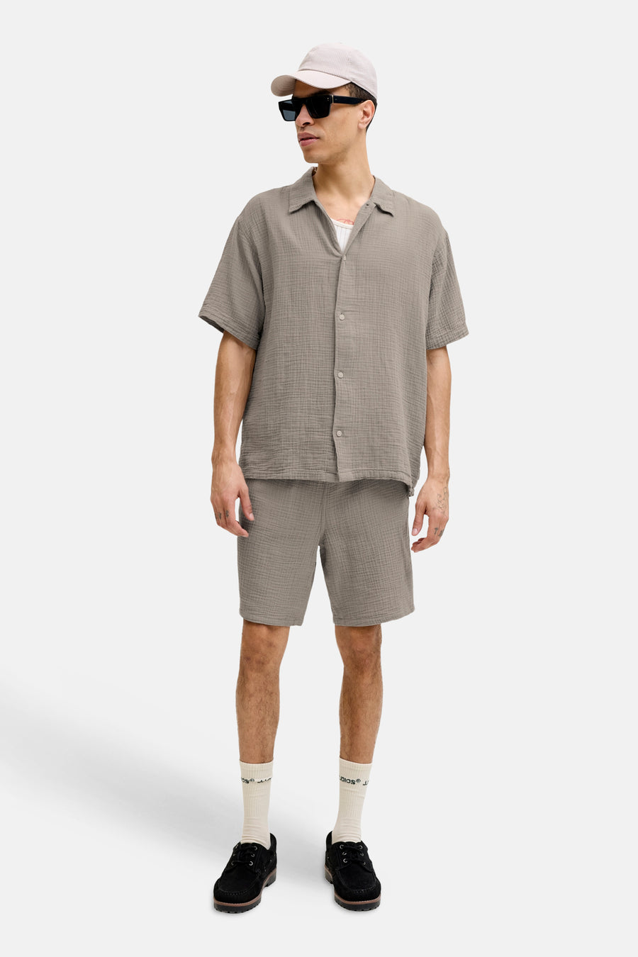 Bruin hemd met korte mouwen van Originals by Jack & Jones, met een korrelige textuur, gedragen met een pet, zonnebril, en korte broek.