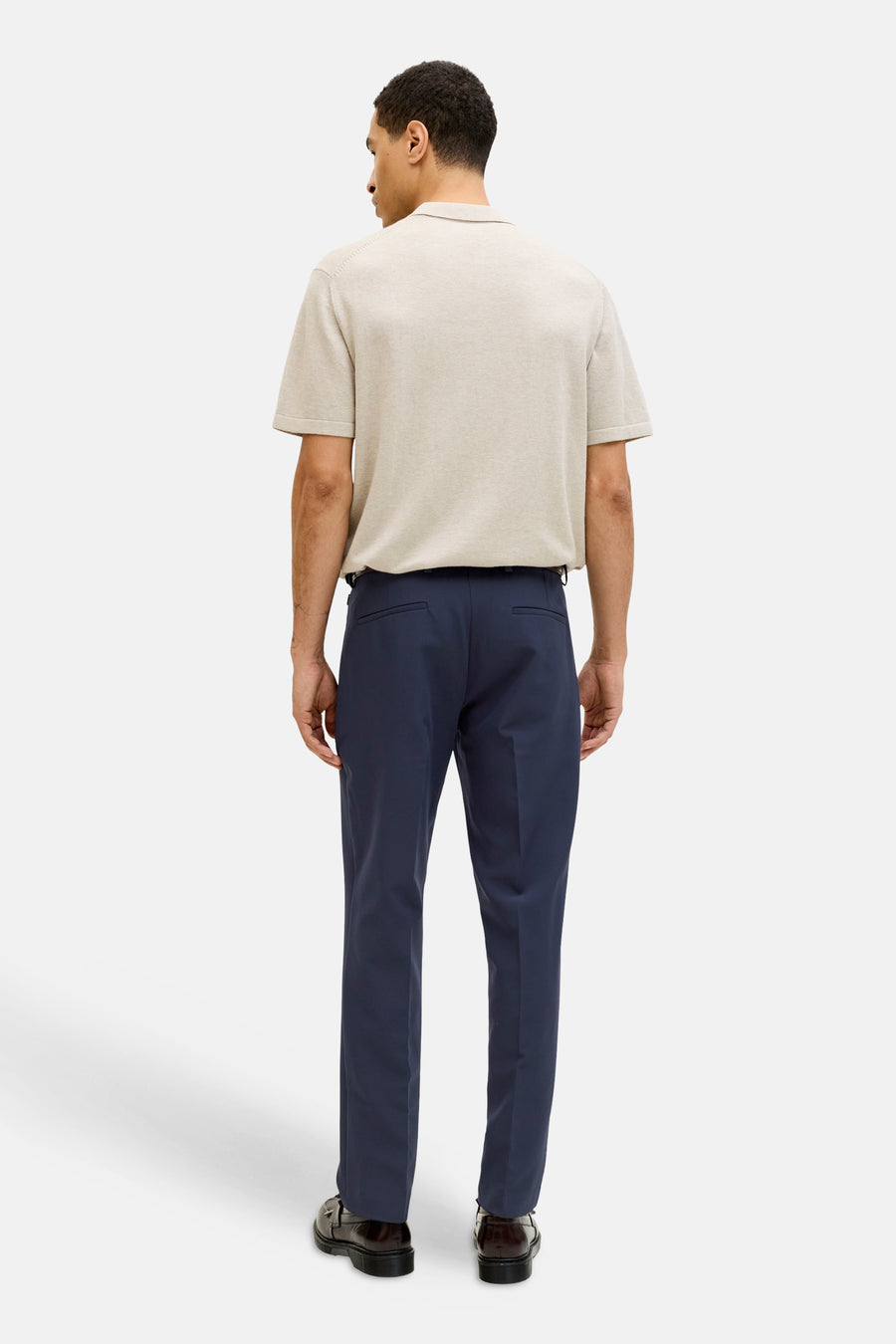 Pantalon de costume bleu de PREMIUM by JACK & JONES, vu de dos, combiné avec un polo beige et des chaussures noires.
