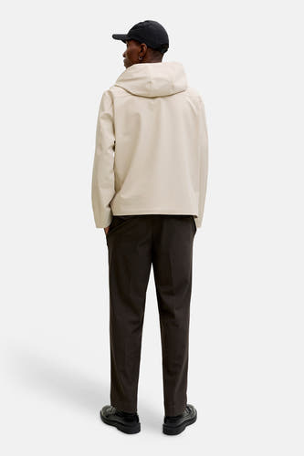Veste courte écru de PREMIUM by JACK & JONES, avec capuche, combinée avec un pantalon foncé et des chaussures noires, vue de dos.