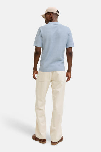Polo bleu à manches courtes de PREMIUM BLUE by JACK & JONES, vue de dos, combinée avec un pantalon crème et une casquette.