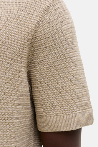 Beige polo met korte mouwen van PREMIUM BLUE by JACK & JONES, met een gebreide textuur en ribgebreide boorden, zijaanzicht.
