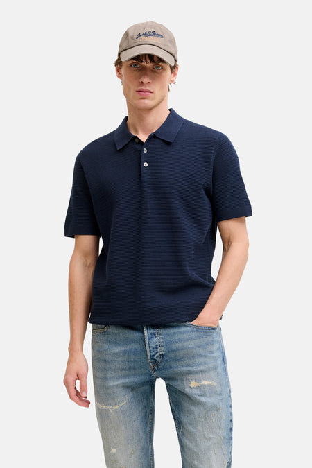 Polo bleu à manches courtes de PREMIUM BLUE by JACK & JONES, porté avec un jean et une casquette.
