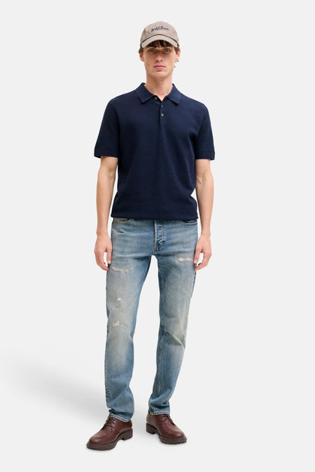 Blauw poloshirt met korte mouwen van PREMIUM BLUE by JACK & JONES, gedragen met jeans en een pet.