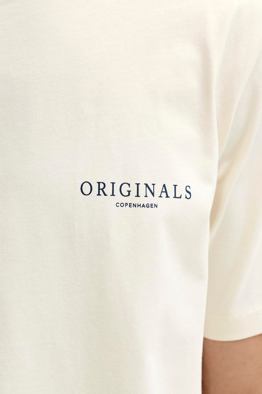 T-shirt écru de ORIGINALS BY JACK & JONES, avec un petit imprimé texte bleu foncé sur la poitrine.