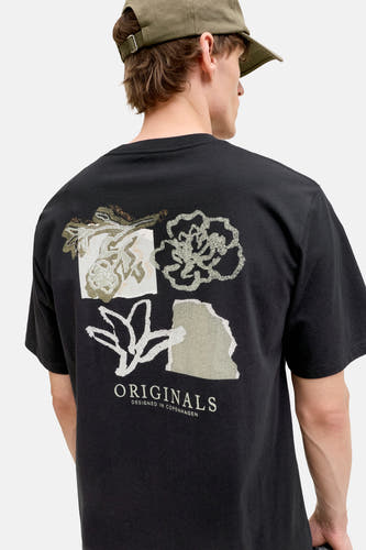 T-shirt noir de ORIGINALS BY JACK & JONES avec un imprimé graphique au dos, porté avec une casquette verte.