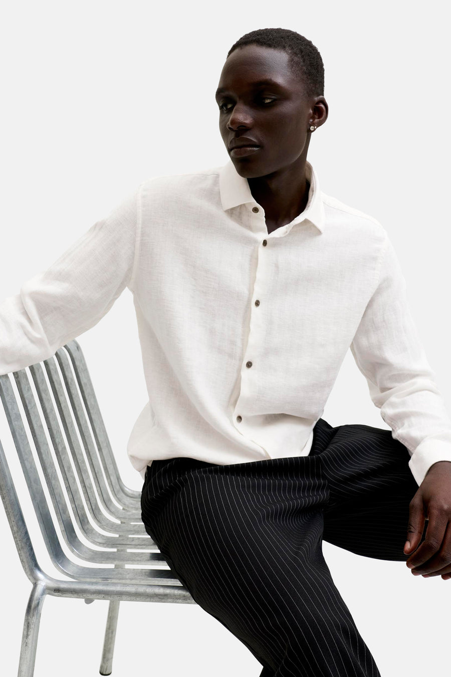 Chemise blanche à manches longues et boutons marron de PREMIUM by JACK & JONES, portée par un homme.