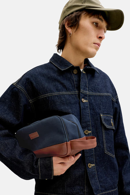 Toilettes bleues d'ACCESSORIES BY JACK & JONES avec des accents en cuir marron, portées par un modèle en veste et casquette en denim.