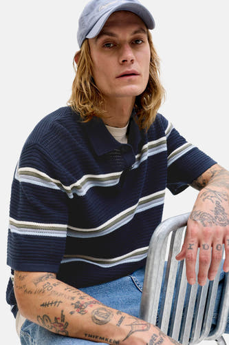 Polo bleu de ORIGINALS BY JACK & JONES, à motif rayé et manches courtes, porté avec une casquette et un jean.