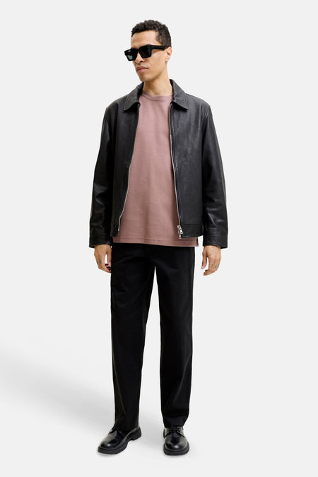 Roze korte mouwen t-shirt van PREMIUM by JACK & JONES, gedragen onder zwarte leren jas, met ronde hals en comfortabele pasvorm, lifestyle shot.