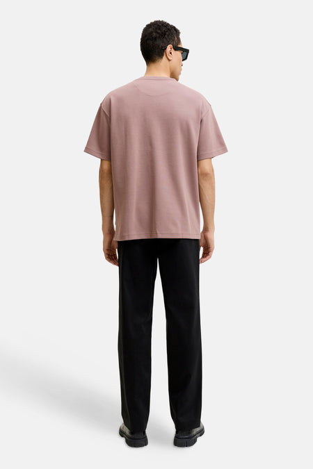 Roze korte mouw t-shirt van PREMIUM by JACK & JONES, achterkant weergegeven, eenvoudig design, model draagt zwarte broek en zonnebril