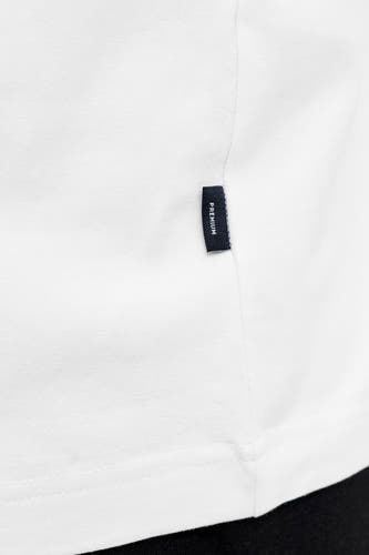 T-shirt blanc à manches courtes de PREMIUM by JACK & JONES, gros plan sur l'ourlet avec une petite étiquette.