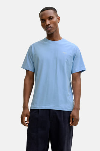 T-shirt bleu à manches courtes de PREMIUM by JACK & JONES, porté avec un pantalon foncé et des mocassins en cuir.