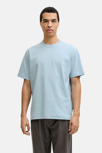 T-shirt bleu à manches courtes de PREMIUM by JACK & JONES, combiné avec un pantalon gris et des chaussures marron.