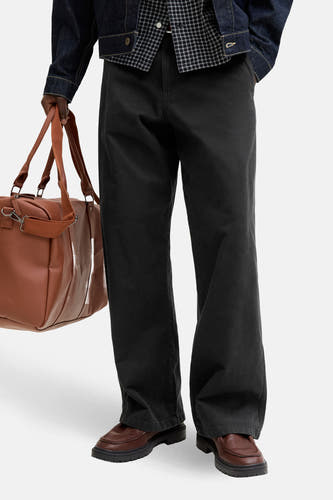 Pantalon noir de JACK & JONES JEANS INTELLIGENCE, à jambes larges et associé à un sac marron et des chaussures en cuir.