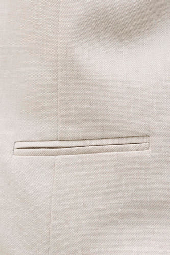 Gilet écru de PREMIUM by JACK & JONES, détail en gros plan avec une poche poitrine et une subtile texture de tissu.