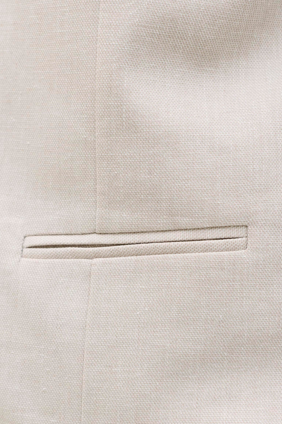 Gilet écru de PREMIUM by JACK & JONES, détail en gros plan avec une poche poitrine et une subtile texture de tissu.