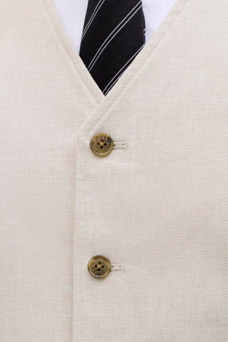 Gilet écru de PREMIUM by JACK & JONES, avec deux boutons, porté sur une chemise blanche avec une cravate noire rayée.