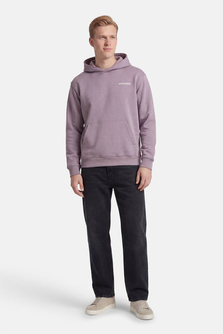 Paarse sweater met kap van CORE BY JACK & JONES, met buidelzak en gedragen met zwarte jeans en beige sneakers.