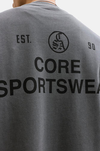 Pull noir à col rond de CORE BY JACK & JONES, avec un logo et un texte imprimés dans le dos.